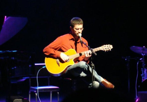 Le Daros sobre palco com viol�o.